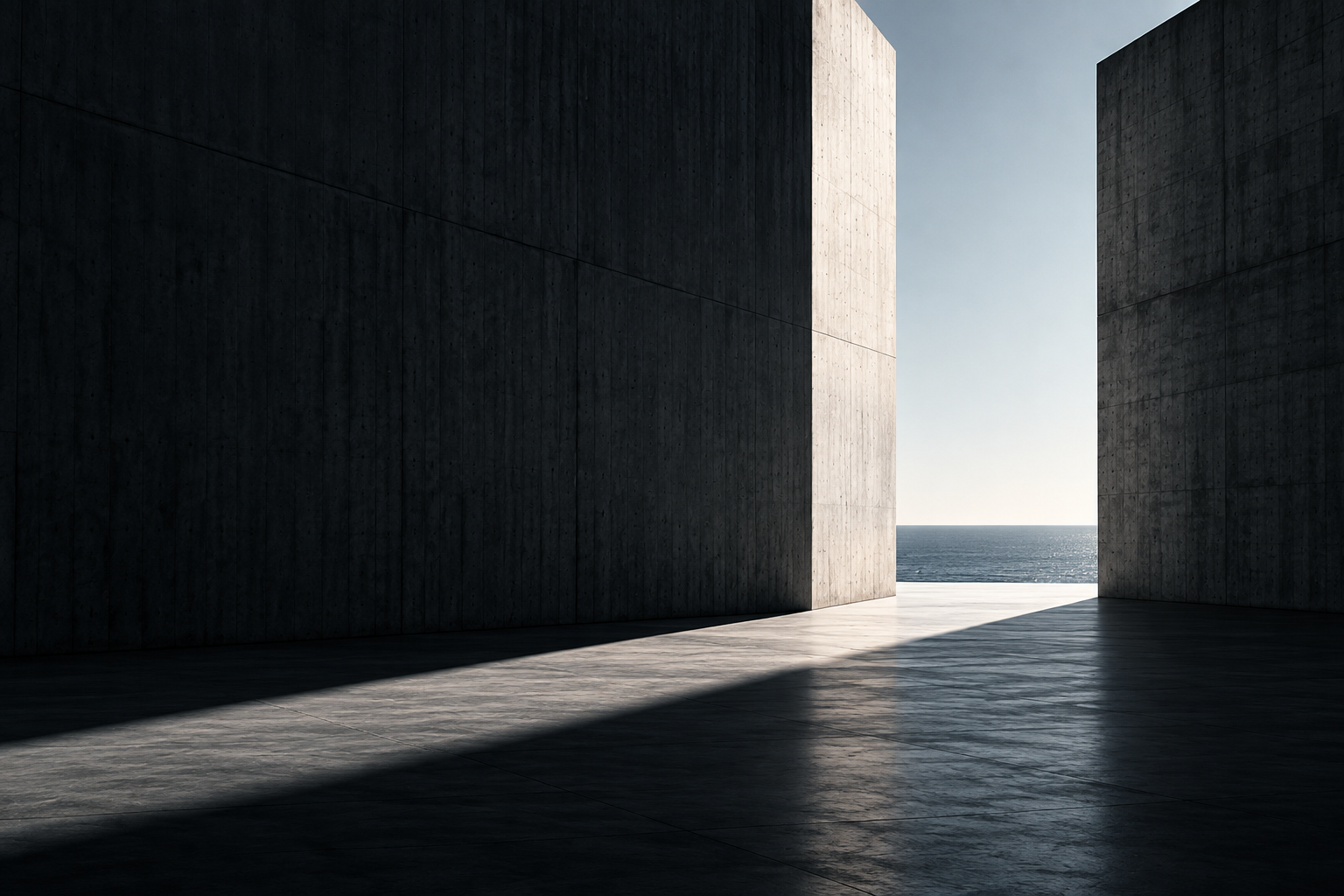 A concrete opening and light path leading toward the sea