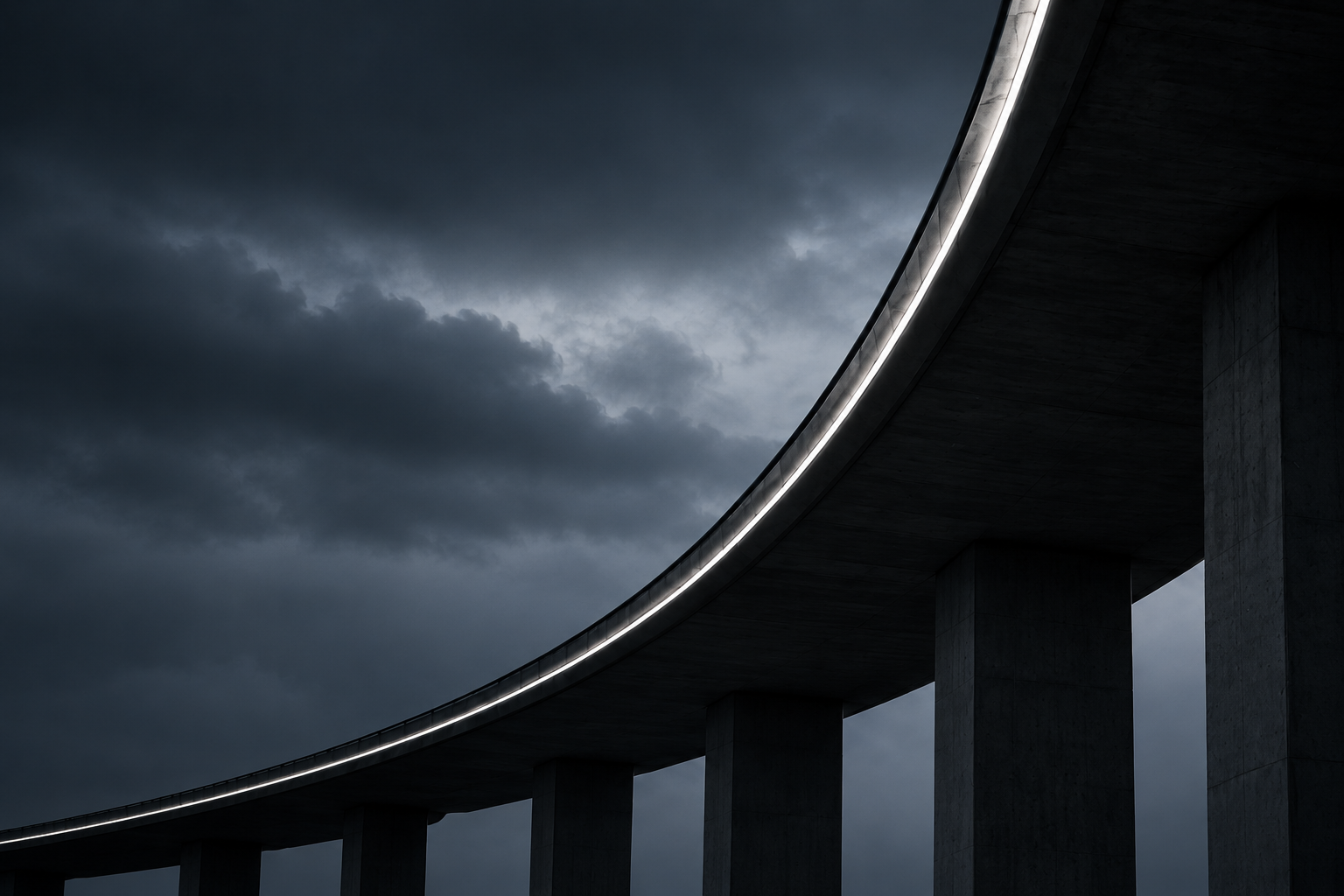 A curved bridge and structural supports beneath a dark sky
